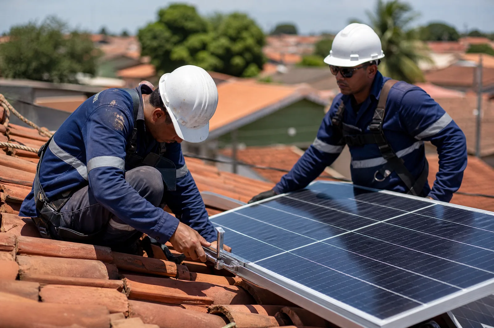Técnicos da Hiperion instalando módulos fotovoltaicos em telhado de telha cerâmica em Cuiabá